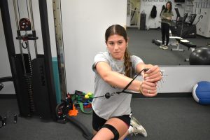 client builds strength and flexibility using weight machine
